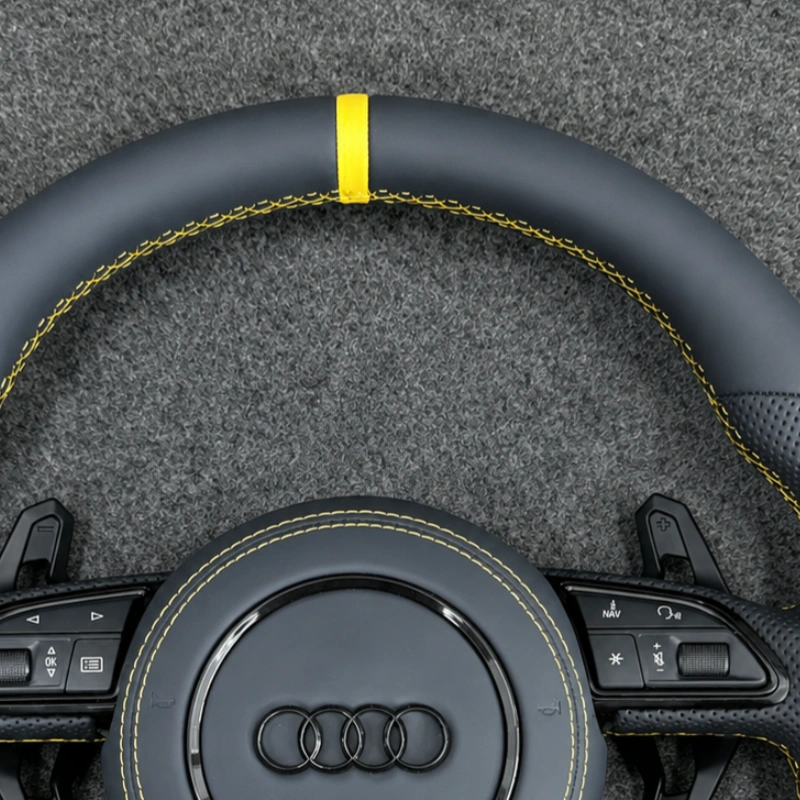Closeup of yellow top center marker, perforated Nappa leather & yellow stitching on Audi B8 steering wheel