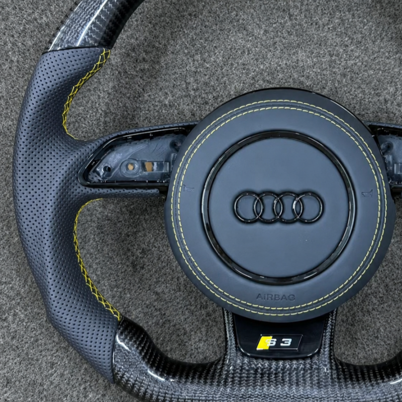 Macro shot of high-gloss forged carbon fiber texture on JIONX Audi sport steering wheel