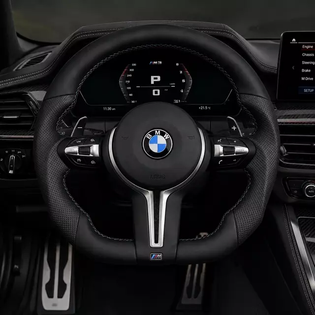 Custom BMW M3 steering wheel installed with perforated leather grips, M-color stitching, silver trim and paddle shifters