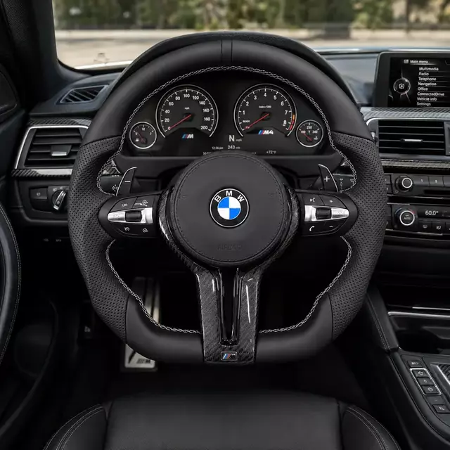 BMW M4 F82 cockpit with an all-black Nappa leather steering wheel, perforated grips, white stitching and carbon fiber trim
