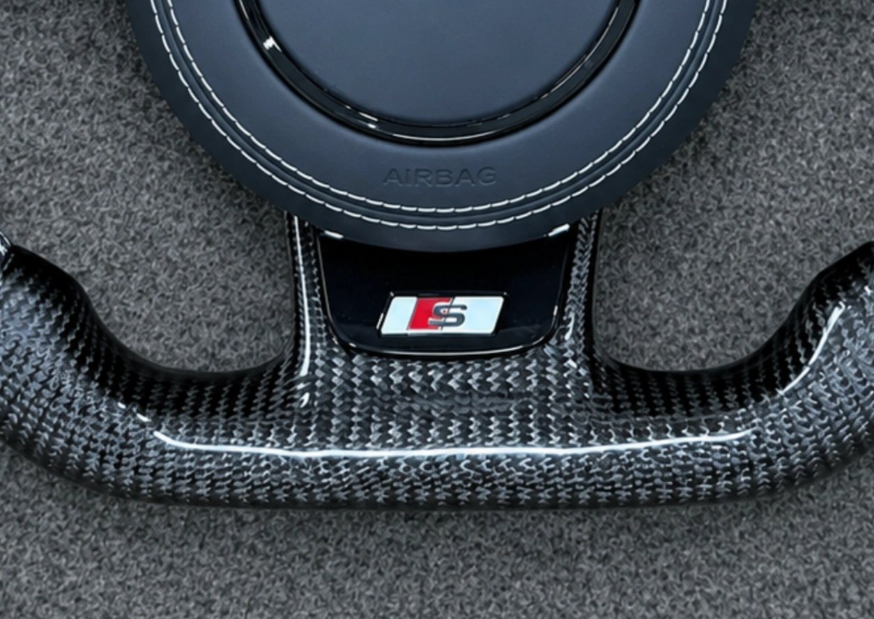 S series sport badge carbon fiber Audi steering wheel closeup JIONX