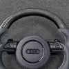 Closeup glossy carbon fiber rim for Audi steering wheel, clear woven racing texture