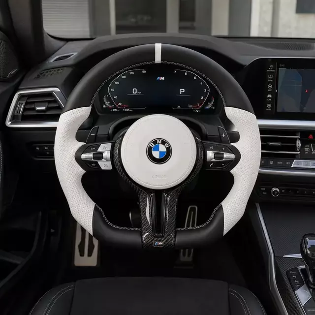 BMW 2 Series interior with an installed black and white carbon fiber flat-bottom steering wheel and paddle shifters