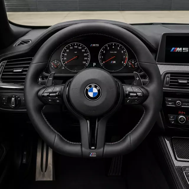 BMW M5 custom black leather steering wheel installed with paddle shifters, controls and M tri-color stitching