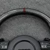 Close-up of dark brown center marker and glossy carbon fiber texture on Audi RS sport steering wheel