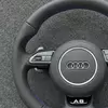 Close up of perforated black Nappa leather grips and purple contrast stitching on Audi flat bottom steering wheel