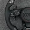 Perforated leather grips with red contrast stitching Audi steering wheel closeup