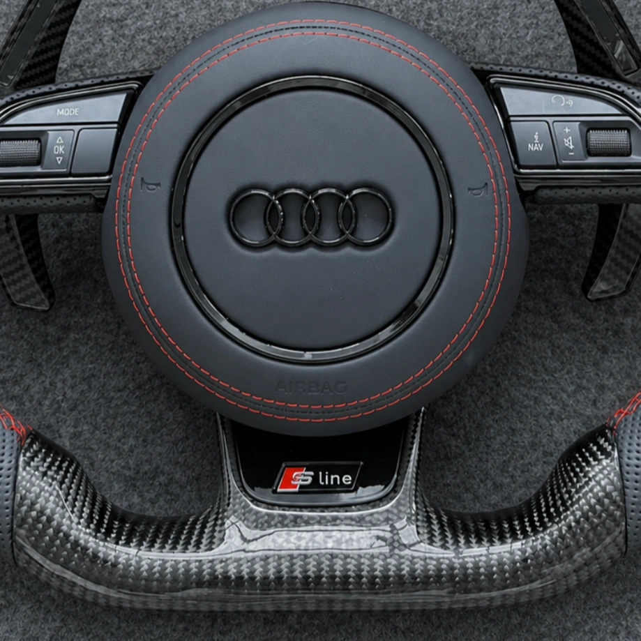JIONX S Line metal badge closeup on gloss carbon fiber steering wheel