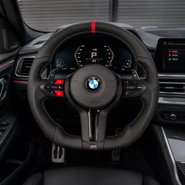 Custom BMW M Sport steering wheel installed in a black performance interior with red center stripe and paddle shifters